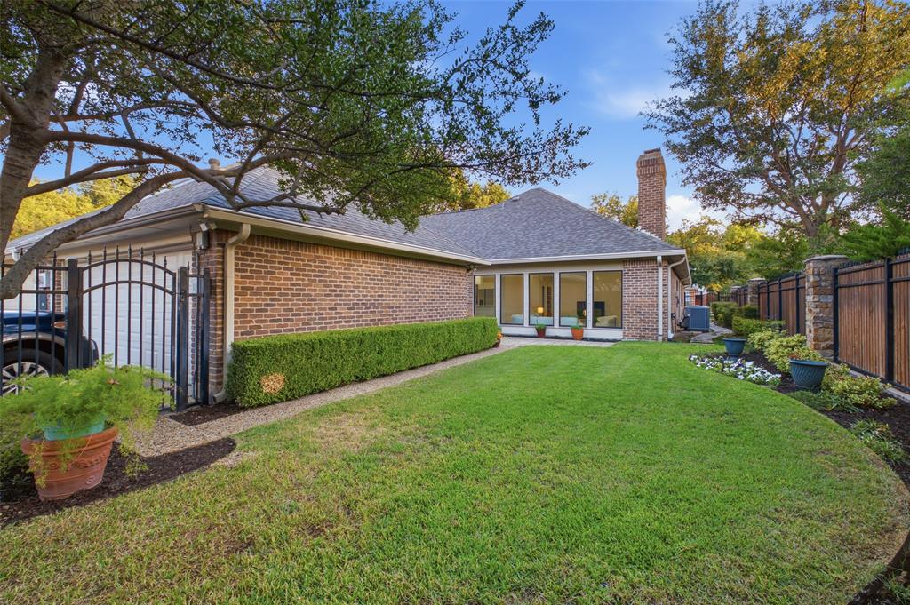 Gated drive to the two-car garage, plus a sweeping, tree-shaded backyard.
