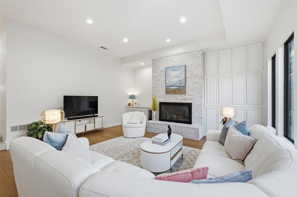 Floor-to-ceiling built-in cabinetry flanks the linear fireplace for storage and style in the heart of the home.