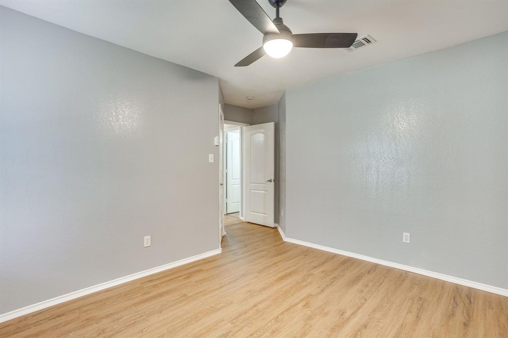 Neutral-toned walls, wood-finish flooring, and a ceiling-mounted matte black light fixture with an integrated fan