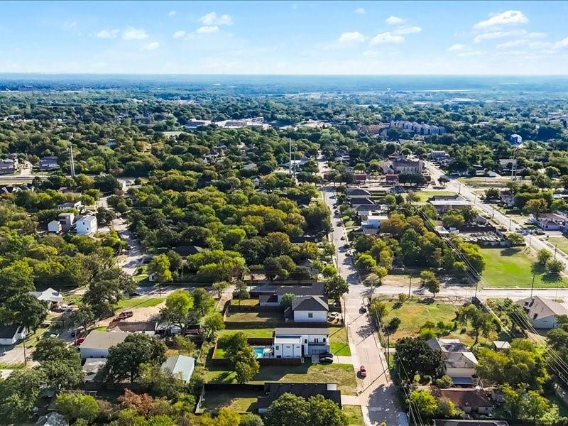 Aerial perspective featuring a residential lot with a backyard swimming pool and mature tree canopy