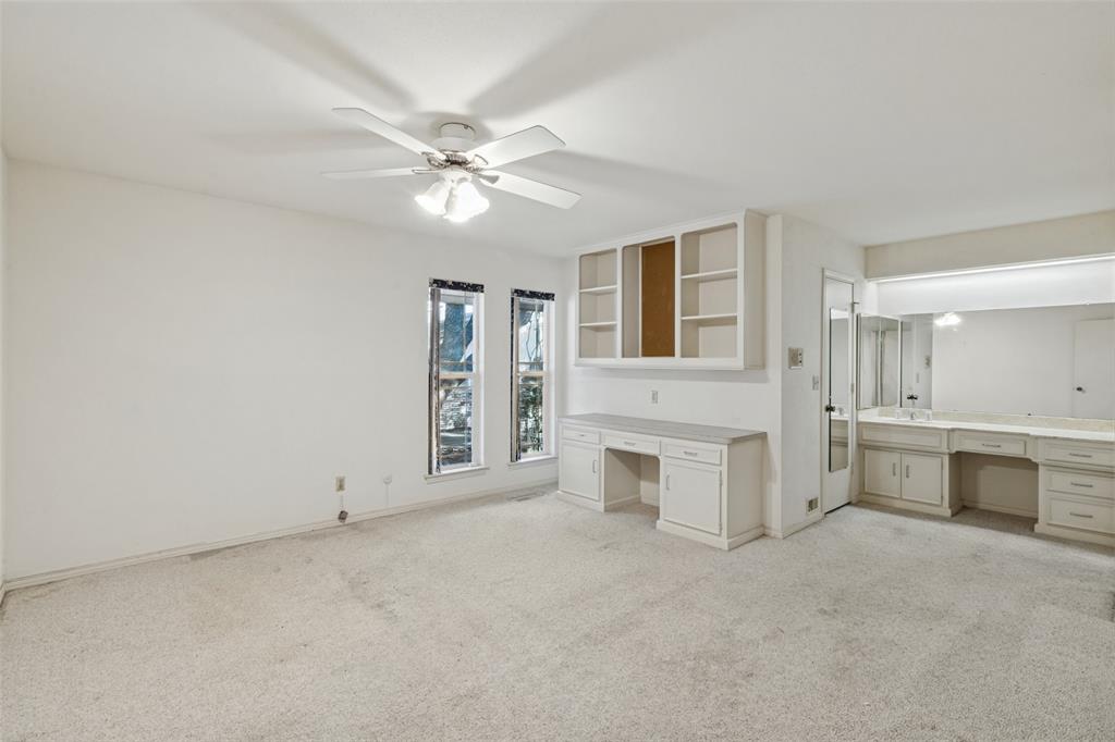 Bedroom with desk area, separate vanity area, large walk-in closet and ceiling fan