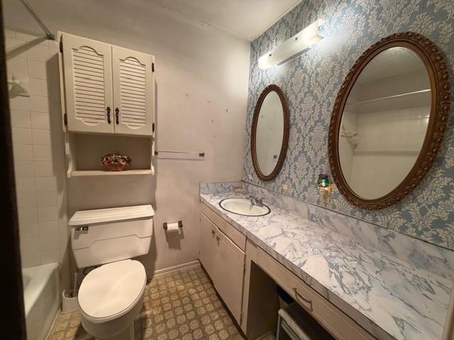 Bathroom featuring vanity with patterned countertop, wall-mounted louvered storage cabinet, two oval wall mirrors, and a tile-surround shower