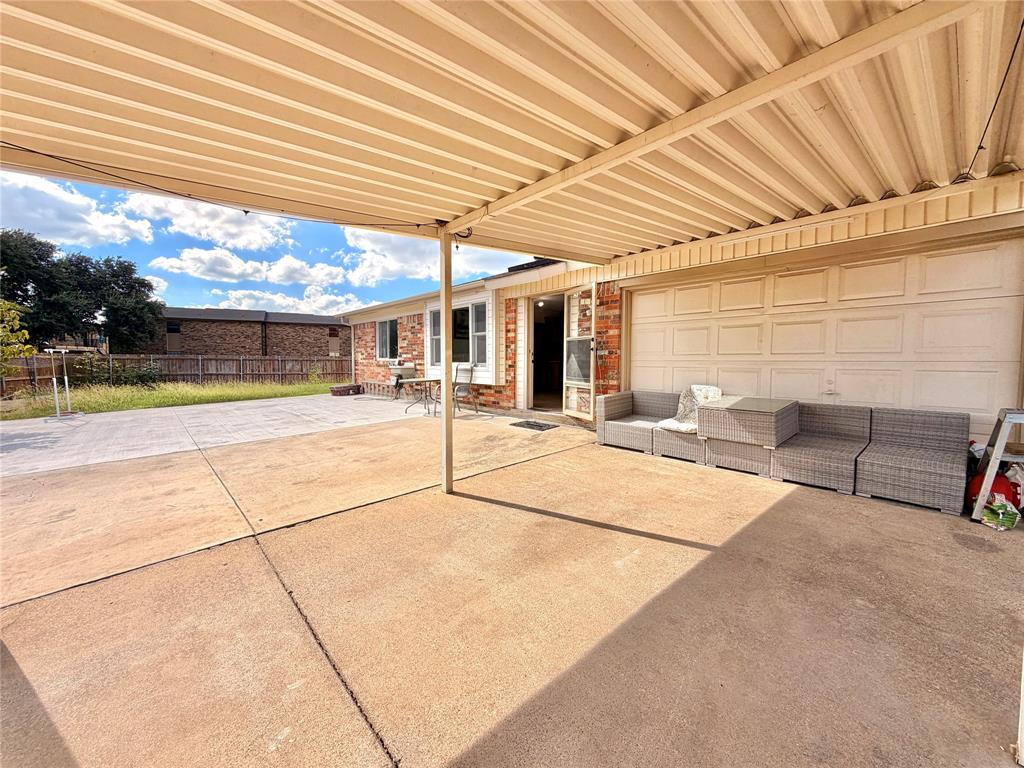 Covered patio featuring a concrete surface, metal support columns, and an attached metal roof structure