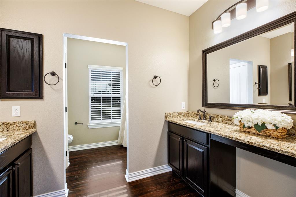 Third bathroom located upstairs with separate vanity counters with sitting area.