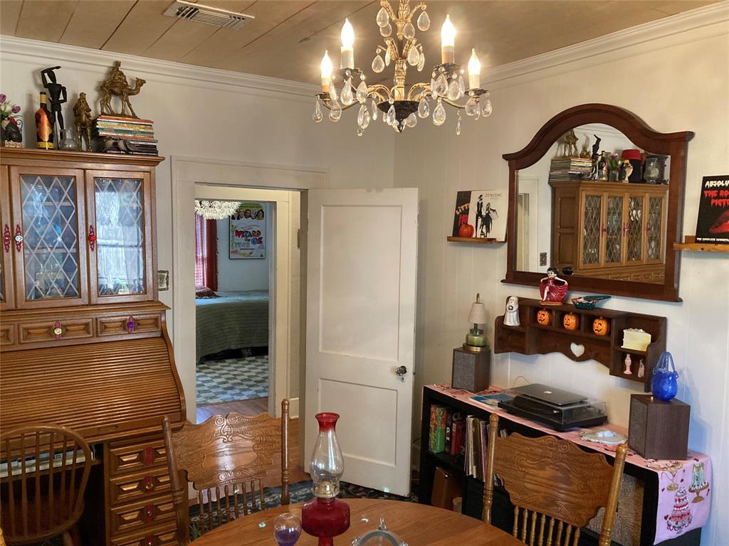 Interior room featuring a wood-plank ceiling, multi-tiered crystal chandelier, and crown molding