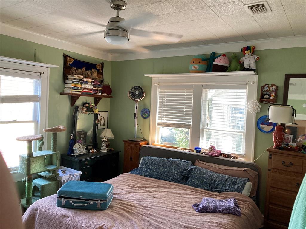 Room featuring a brushed-nickel ceiling fan with integrated lighting, multi-pane windows with horizontal blinds, and built-in wall shelving