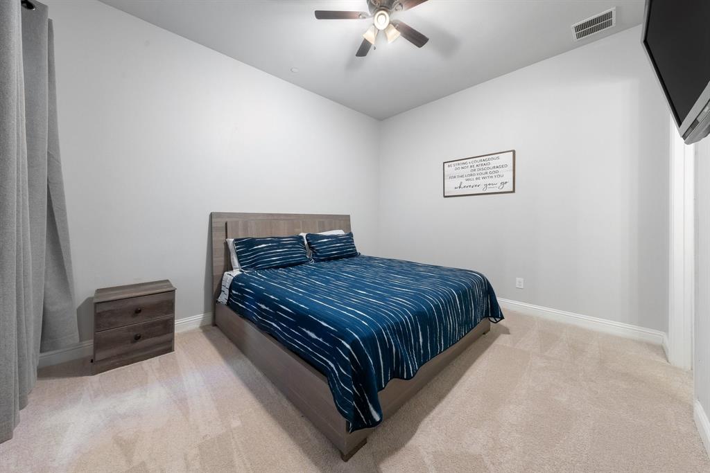 Neutral-toned carpeted flooring, high ceilings, and an attached multi-blade ceiling fan with integrated lighting