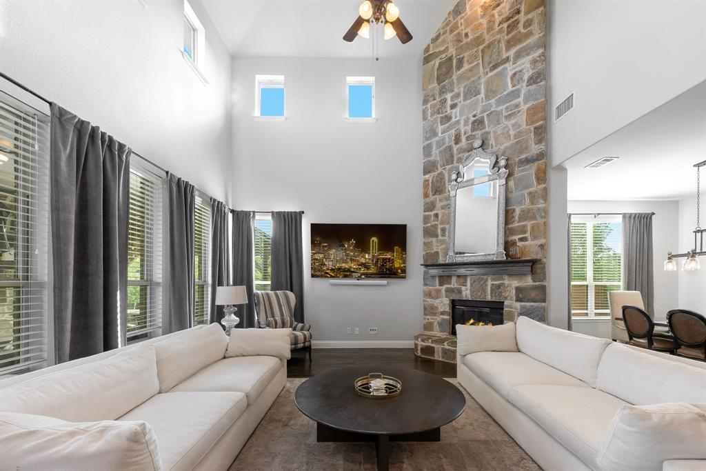 Floor-to-ceiling stone fireplace, soaring vaulted ceilings, and multi-level windows providing natural light