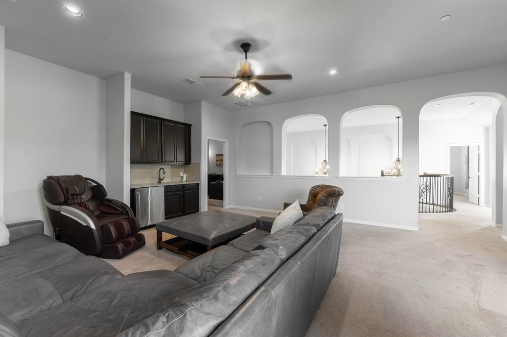 Built-in cabinetry with stainless steel under-counter refrigeration, arched wall niches, recessed ceiling lighting, and a ceiling fan