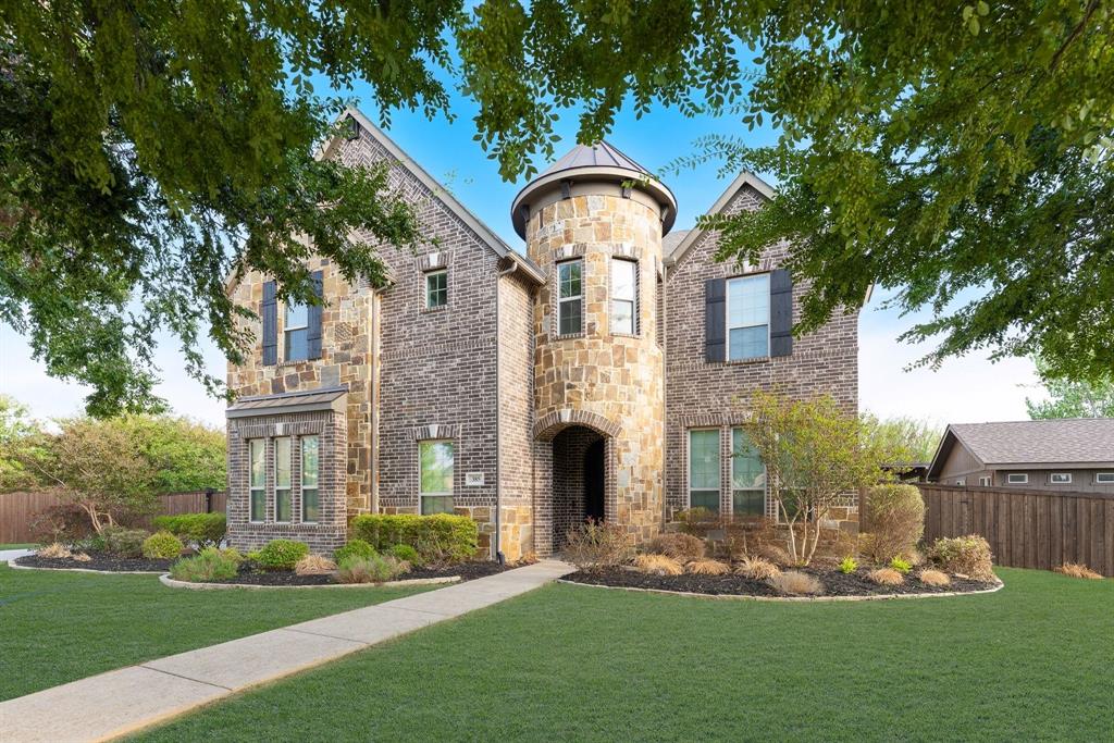 Multi-story exterior featuring a stone and brick facade, central turret architecture, dark shutters, and a concrete walkway