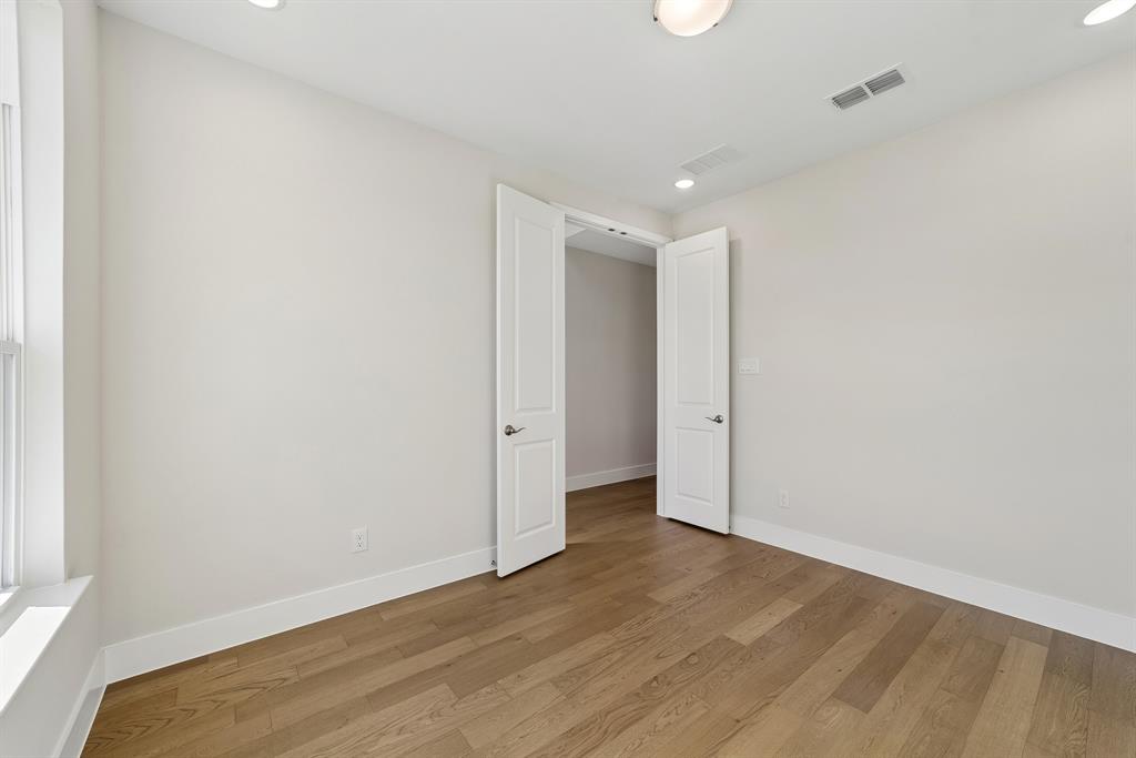 Room featuring wood-finish flooring, recessed lighting, and white two-panel interior doors