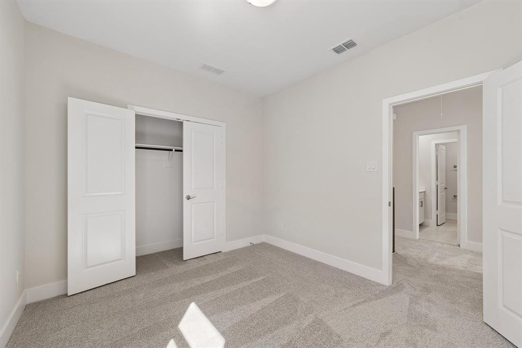 Neutral interior featuring wall-to-wall carpeting, two-panel interior doors, and a reach-in closet with built-in shelving