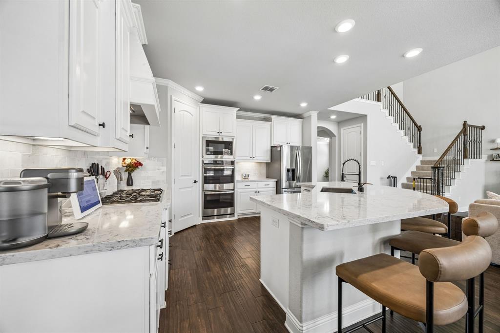 Bright kitchen with stainless appliances and gas cooktop.