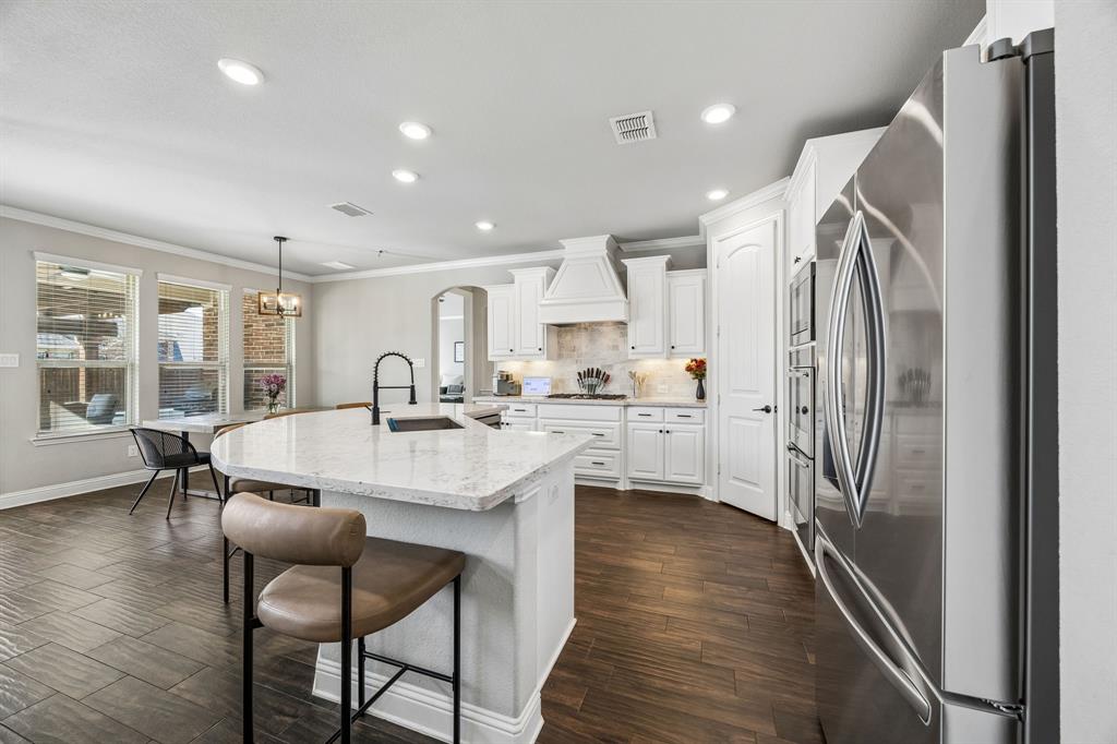 Bright kitchen with stainless appliances and gas cooktop.
