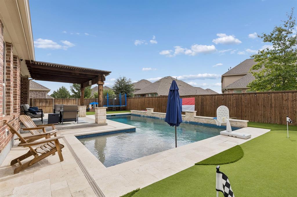 This backyard has it all. Pool with heater, per friendly turf and a 3 hole putting green!