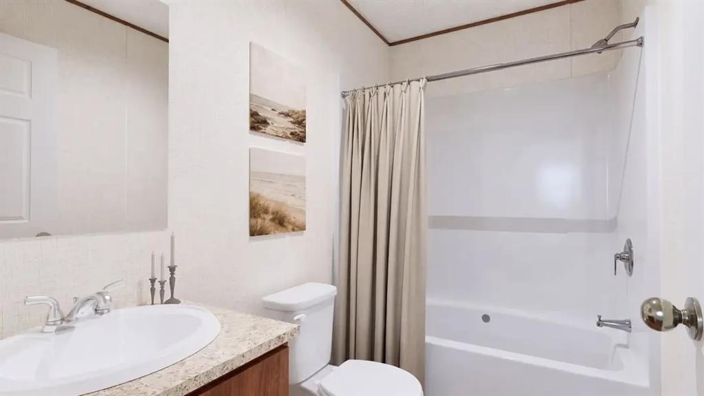 Bathroom featuring a vanity with a stone-finish countertop, an oval drop-in sink, a wall-mounted mirror, and a combination tub and shower with a chrome fixture