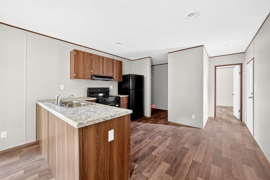 Kitchen featuring wood-finish cabinetry, stone-patterned countertops, wood-finish flooring, and recessed ceiling lighting