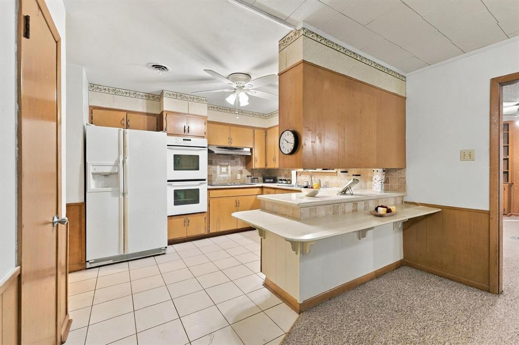 Built in cabinetry with double oven, stove top, plenty of cabinetry and a multi-level peninsula with a countertop extension