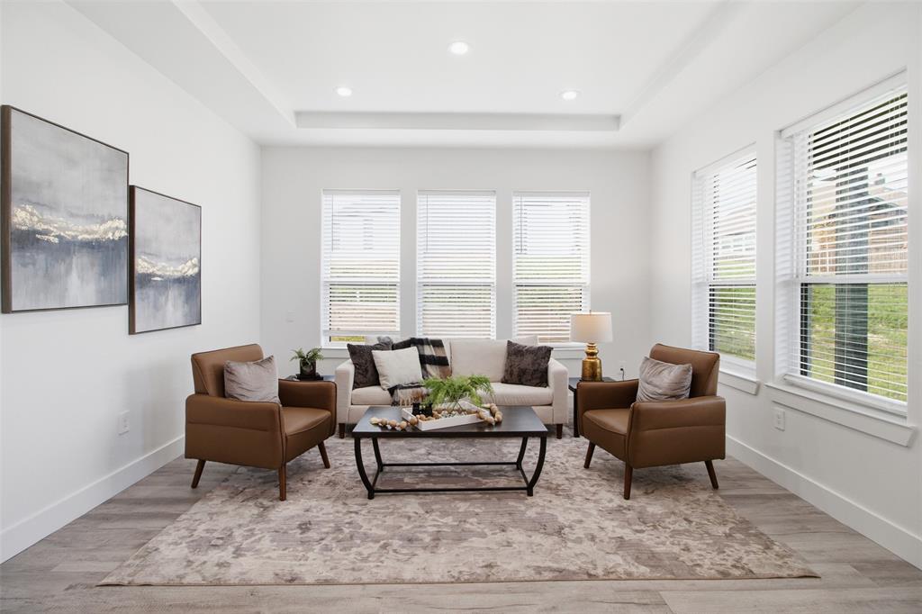 Tray ceiling featuring recessed lighting, wood-finish flooring, and expansive windows