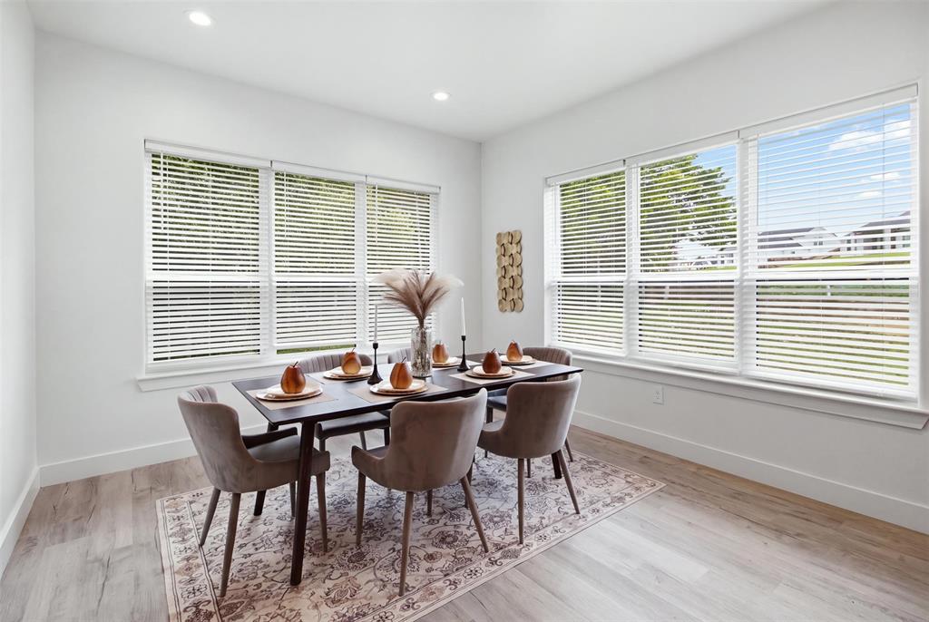 Bright room featuring wood-finish flooring, recessed lighting, and multiple large windows with horizontal blinds