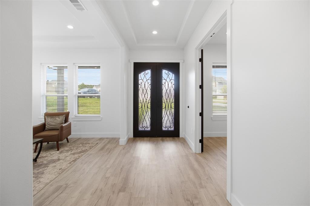 Entryway featuring double iron-glass doors, wood-finish flooring, recessed lighting, and a tray ceiling