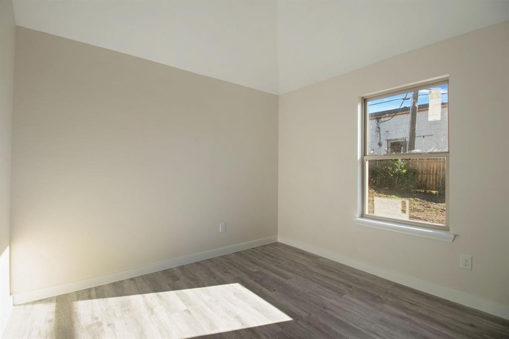 Neutral-toned walls, wood-finish flooring, and a single window with white trim