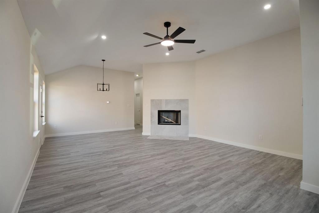 Vaulted ceilings, recessed lighting, and a modern ceiling fan illuminate this expansive room