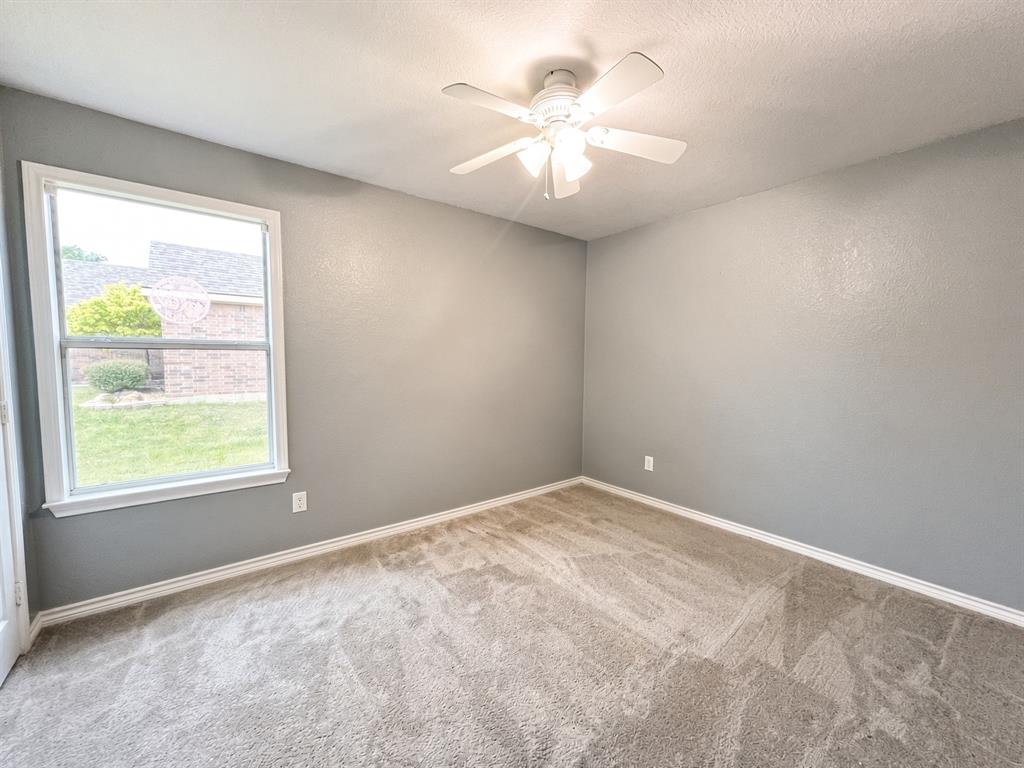 Room featuring neutral wall paint, wall-to-wall carpeting, a multi-light ceiling fan, and a single-pane window
