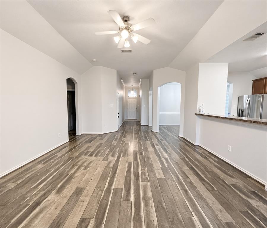 Vaulted ceilings, wood-finish flooring, recessed lighting, ceiling fan with light kit, and arched architectural entryways Vaulted ceilings, wood-finish flooring, recessed lighting, ceiling fan with light kit, and arched architectural entryways