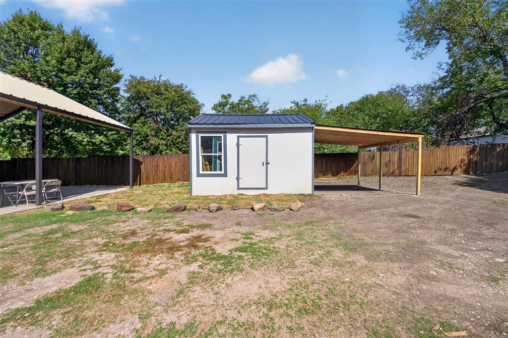 Detached storage building featuring a metal roof and adjoining covered area offering additional space for outdoor storage and equipment.