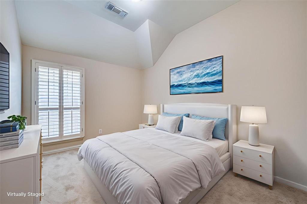 Vaulted ceiling, neutral wall tones, and plantation-style window shutters