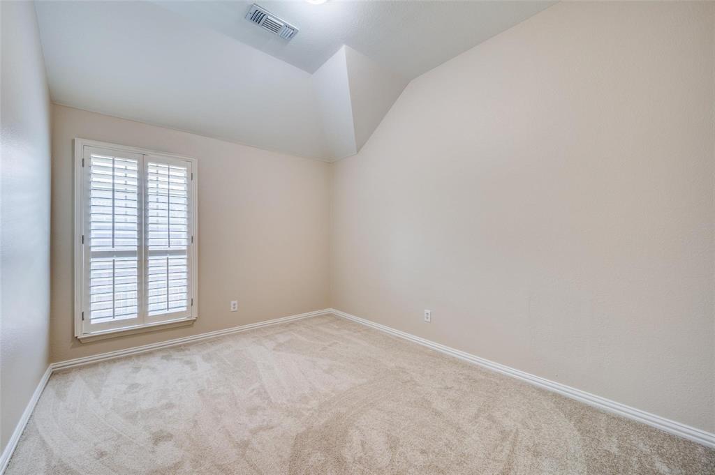 Vaulted ceiling, neutral wall tones, wall-to-wall carpeting, and interior plantation shutters
