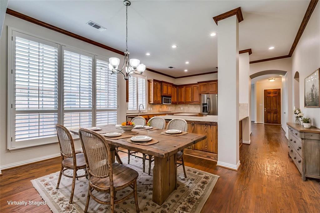 Dining area featuring wood-finish flooring, plantation shutters, crown molding, and a chandelier, complemented by recessed lighting
