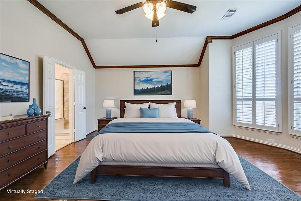 Vaulted ceiling featuring wood-finish crown molding, plantation shutters, and a ceiling fan with integrated lighting