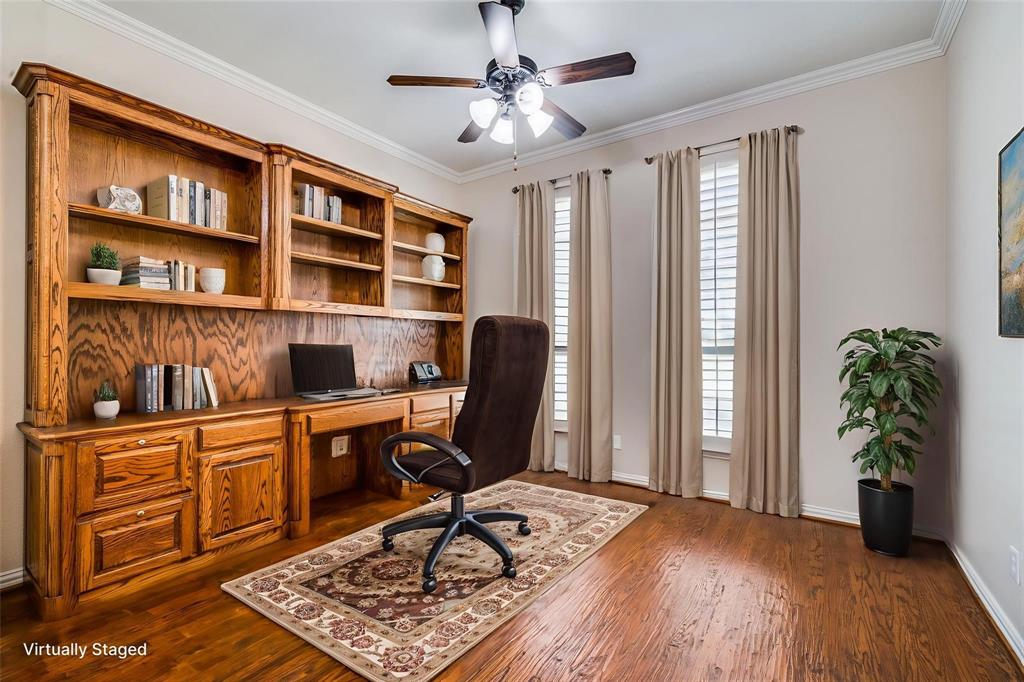 Custom built-in wood cabinetry with integrated desk space and open shelving, wood-finish flooring, crown molding, and plantation shutters