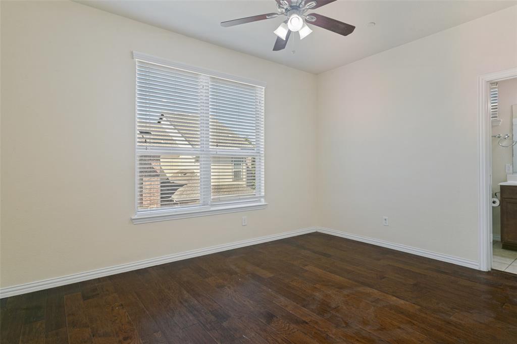 Room featuring wood-finish flooring, a ceiling fan with integrated lighting, and a window with horizontal blinds