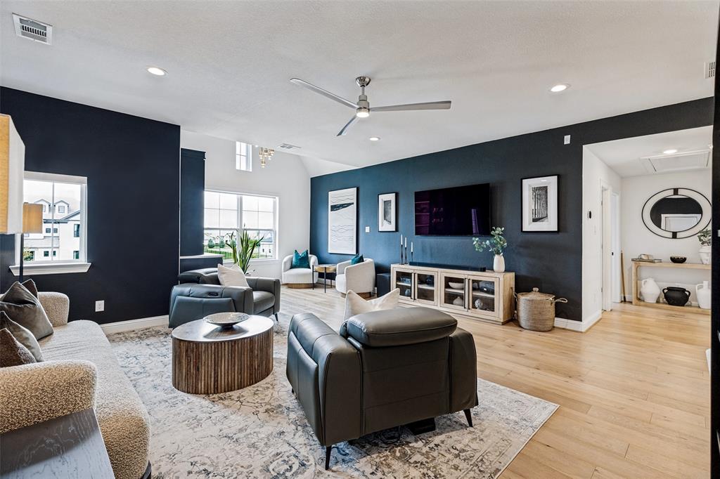 Open-concept living space featuring vaulted ceilings, wood-finish flooring, recessed lighting, and a modern ceiling fan