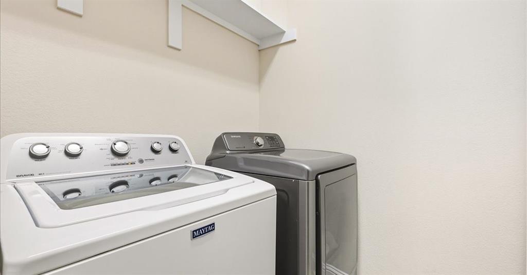 Utility area featuring wall-mounted storage shelving