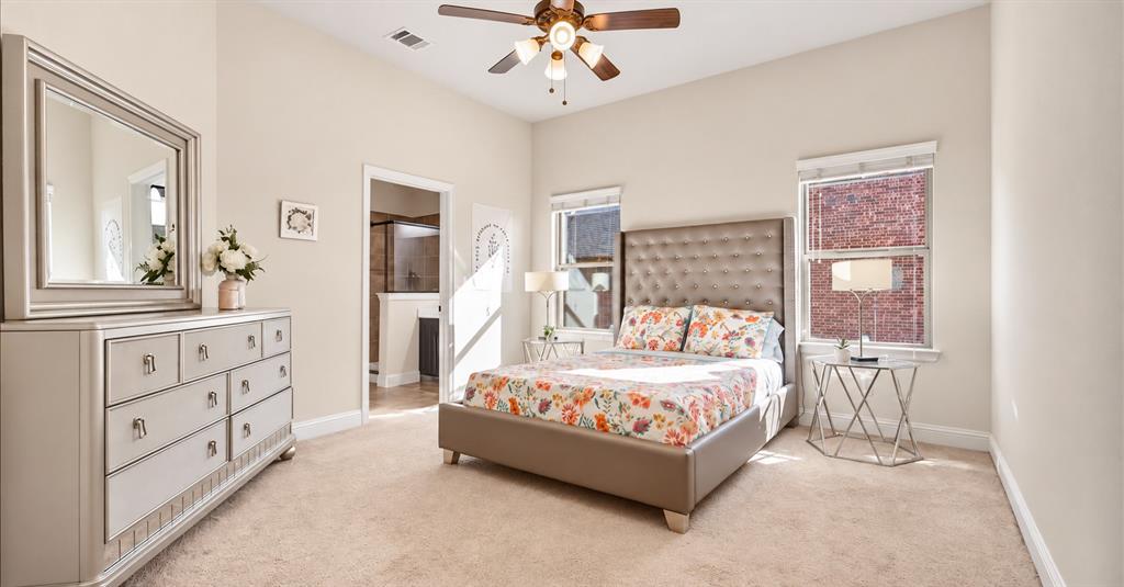 High-ceiling bedroom featuring neutral carpeting, a central multi-light ceiling fan, and two windows with blinds