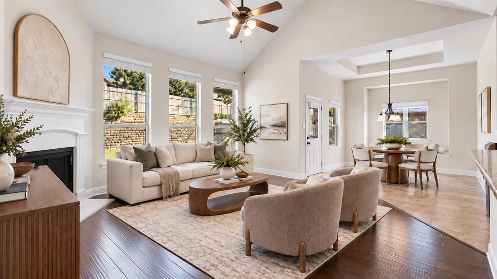 Vaulted ceilings, fireplace with decorative mantel, wood-finish flooring, tile flooring, and oversized windows