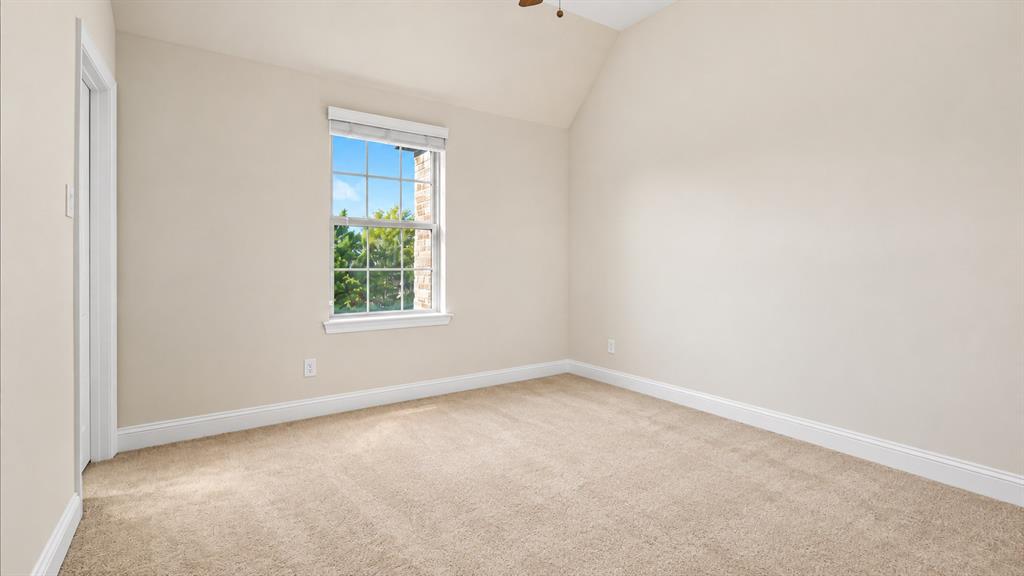 Vaulted ceiling, wall-to-wall carpeting, and a grid-pattern window with exterior brick detail