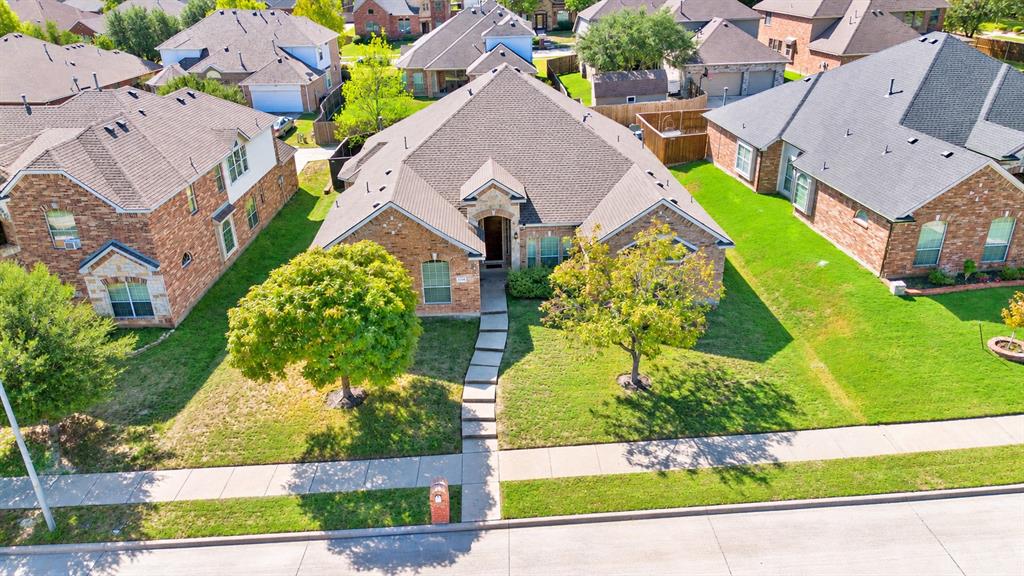 Single-story brick exterior featuring a multi-gabled roofline, stone accents, concrete walkway, and manicured front lawn