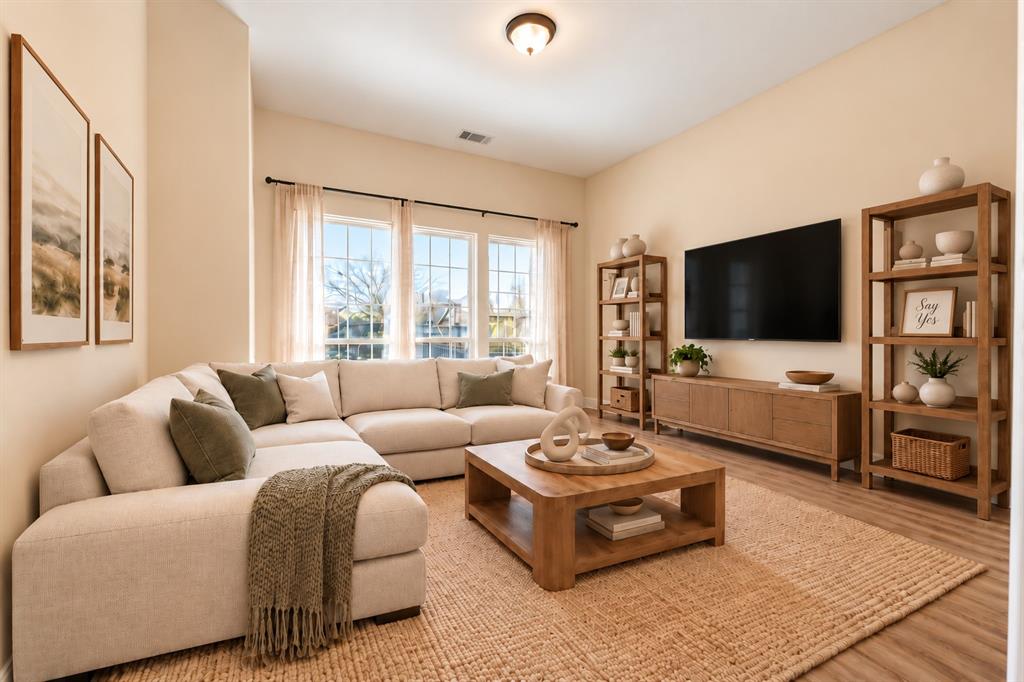 High-ceilinged room featuring wood-look LVP flooring, large multi-pane windows, and a flush-mount ceiling light fixture. *Virtually staged to show potential* High-ceilinged room featuring wood-look LVP flooring, large multi-pane windows, and a flush-mount ceiling light fixture. *Virtually staged to show potential*