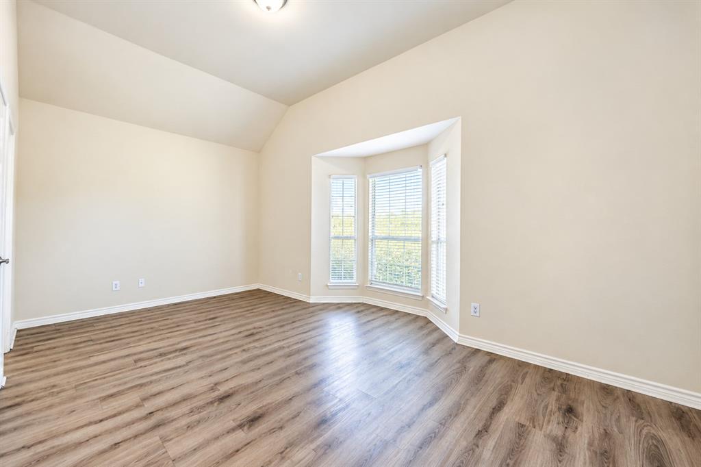 Vaulted ceilings, wood-look LVP flooring, and a triple-pane bay window