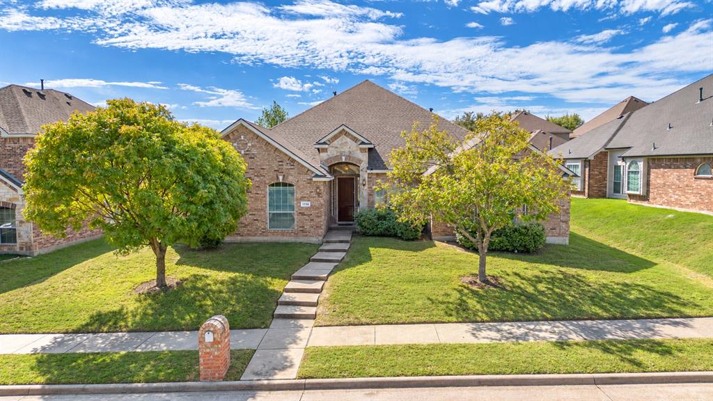 Brick exterior featuring a gabled roofline, stone accents around the arched entryway, a paved walkway, and a brick-faced mailbox Brick exterior featuring a gabled roofline, stone accents around the arched entryway, a paved walkway, and a brick-faced mailbox