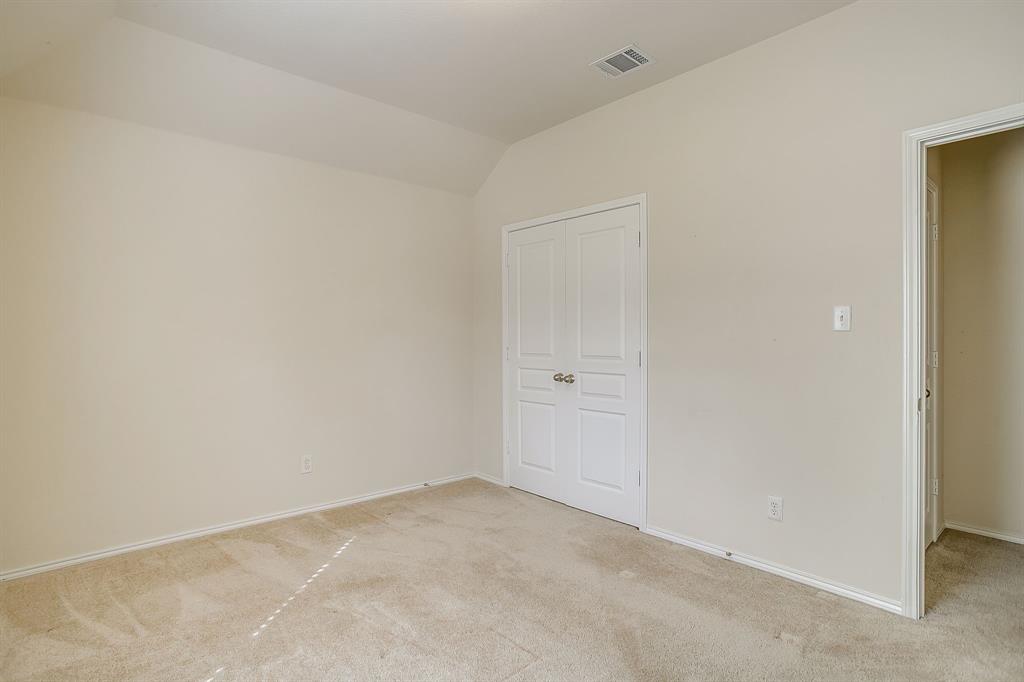 Neutral-toned room featuring vaulted ceilings, carpeting, and double-panel closet doors