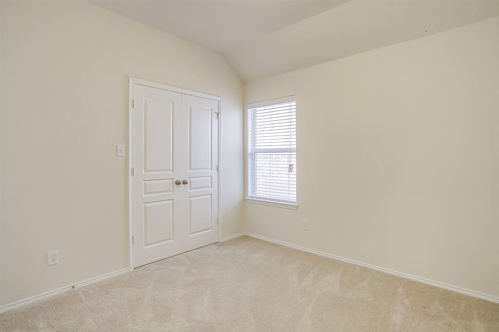 Room featuring neutral-toned carpeting, off-white wall finishes, a single-pane window with horizontal blinds, and double-panel closet doors with spherical knobs