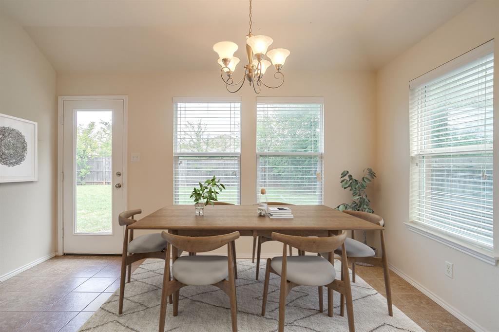 Breakfast area featuring neutral tile flooring, five-light chandelier, and large windows with horizontal blinds