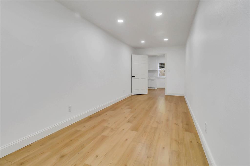 Interior space featuring wood-finish flooring, crisp white walls, and recessed ceiling lighting