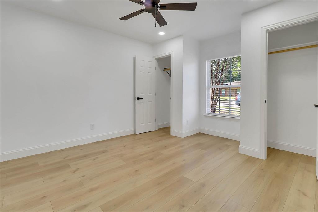 Room featuring wood-finish flooring, recessed lighting, a ceiling fan, a single-pane window, and two separate reach-in closets